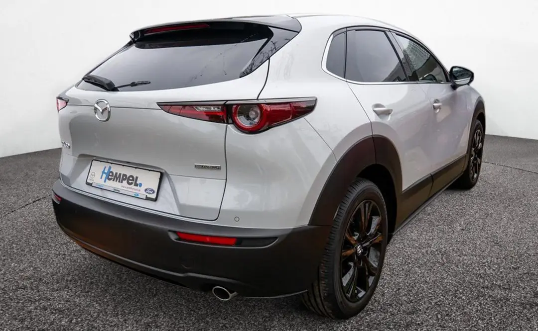 Heck eines Mazda CX-30 in der Farbe ceramic-white, der auf dem Hof des Autohauses Hempel in Braunschweig steht.