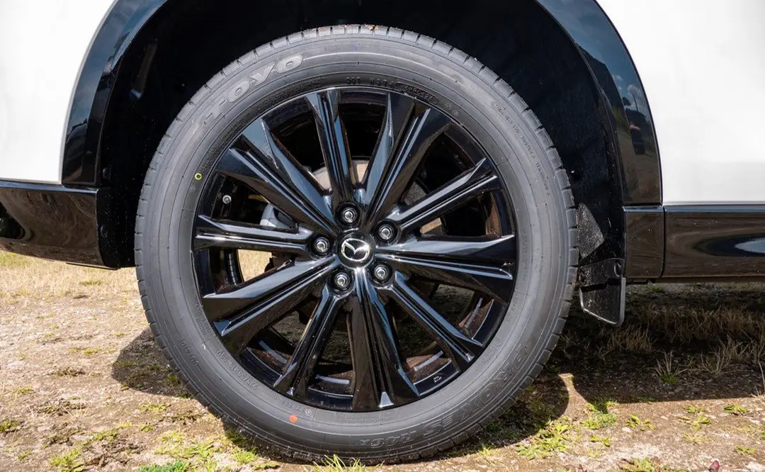 Rad und schwarze Felgen eines Mazda CX-5 in der Farbe weiß, der auf dem Hof des Autohauses Hempel in Braunschweig steht.