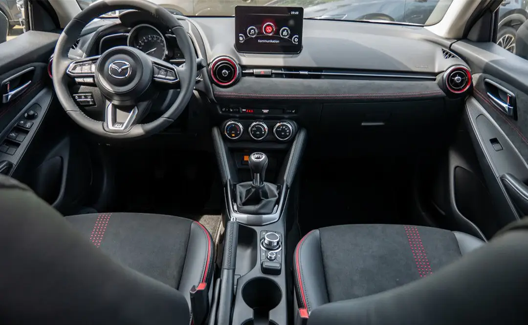 Innenraum mit Fahrer- und Beifahrersitz eines Mazda 2 in der Farbe machine-grey, der auf dem Hof des Autohauses Hempel in Braunschweig steht.