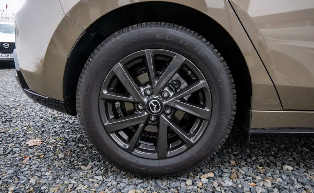 Räder und schwarze Felgen eines Mazda 3 in der Farbe platinum-quartz, der auf dem Hof des Autohauses Hempel in Braunschweig steht.